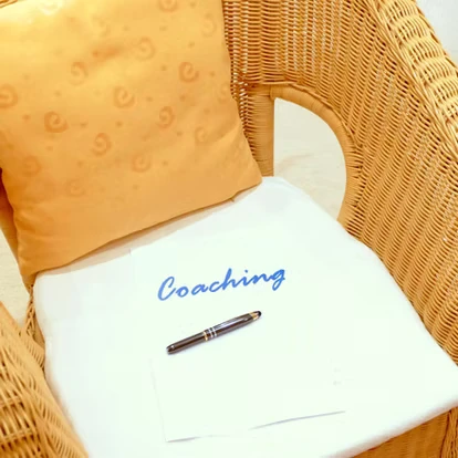 Ein mit Coaching beschriftetes Papier auf einem Korbstuhl